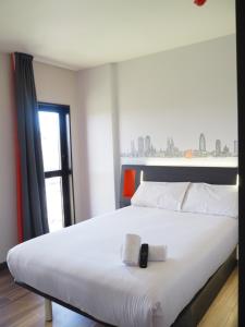 a bedroom with a large white bed with a window at easyHotel Barcelona Fira in Hospitalet de Llobregat