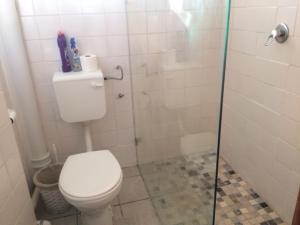 ストランドにあるRomilly Beach Apartmentのバスルーム(トイレ、ガラス張りのシャワーブース付)