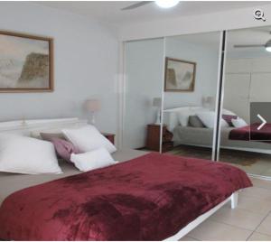 Un dormitorio con una cama grande y un espejo. en Romilly Beach Apartment, en Strand