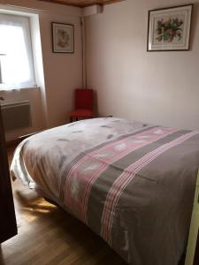 a bedroom with a bed and a red chair at Maison à Font-Romeu - Odeillo in Odeillo-Via