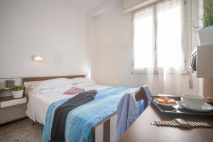 a bedroom with a bed and a table with a tray of food at Hotel Bologna in Misano Adriatico
