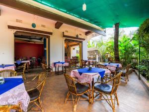 a restaurant with tables and chairs with purple tablecloths at Sea View Resort in Patnem