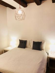 a bedroom with a white bed with two lamps at Al Belenzani Appartamento in Trento