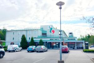 a building with cars parked in a parking lot at Good Morning Kista in Stockholm