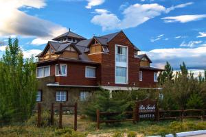 un gran edificio marrón con un cartel delante en Rio Tarde Casa Patagonica en Lago Posadas