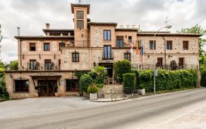 un gran edificio de ladrillo en el lateral de una calle en Hotel Los Cigarrales, en Toledo