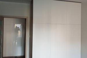un gran armario blanco en una habitación con puerta en Apartament New York Różana 19, en Poznan