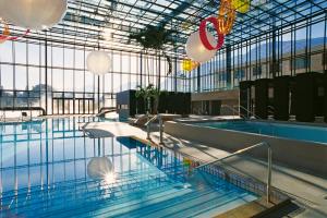 - une grande piscine dans un bâtiment doté d'un grand plafond dans l'établissement Appartment Larcher - Manzoni, à Merano