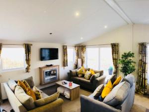 a living room with two couches and a fireplace at Camber coast holidays in Camber