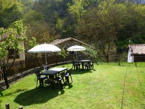 three tables and chairs with umbrellas in a yard at Albergue Turístico Briz in Espinama