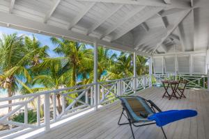 a chair on a porch with a view of the beach at Tantalus in Bridgetown