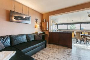 Il comprend un salon avec un canapé et une cuisine. dans l'établissement Villa Naturiste Port Venus, au Cap d'Agde