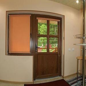Pokój z drewnianymi drzwiami i oknem w obiekcie КОМФОРТ w mieście Karpaty