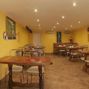 КОМФОРТ في كارباتي: غرفة طعام بها طاولات وكراسي وجدران صفراء