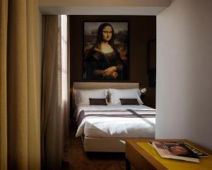 a painting of a woman sitting on a bed in a bedroom at The Frame Hotel in Florence