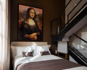 a bedroom with a large painting of a woman at The Frame Hotel in Florence