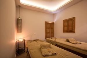 a room with two beds and a light on the ceiling at Erato by Samian Mare in Karlovasi