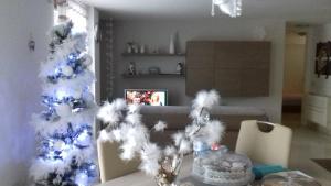 uma árvore de Natal branca numa sala de estar com uma mesa em La Casa Di Melory em Matera