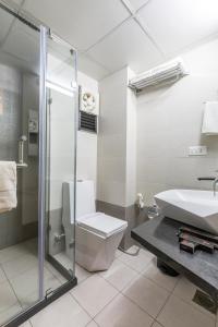 y baño con aseo, lavabo y ducha. en Prominent Corporate Residency en Gandhinagar