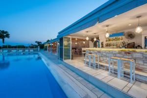 a swimming pool with a bar next to a resort at Saint George Hotel in Chrissi Akti