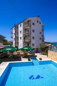 um hotel com piscina em frente a um edifício em B&B Villa Paula em Trogir