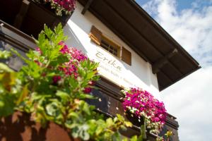 un edificio con flores a un lado. en Hotel Erika en San Vigilio Di Marebbe