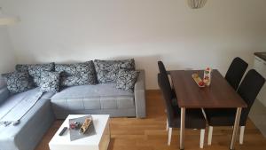 salon z kanapą i stołem w obiekcie Apartman Mir w mieście Zlatibor