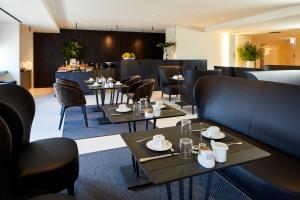 a restaurant with tables and chairs and a bar at Delparco Hotel in Buttrio