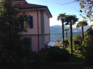 Reno Di LeggiunoにあるVilla Maria Lago Maggioreの水の見えるピンクの家