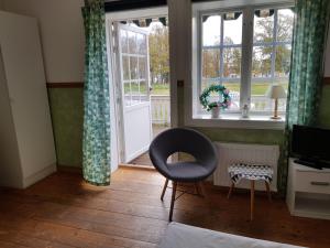 a living room with a chair and a window at Röda Stallet Bed & Breakfast in Hjo