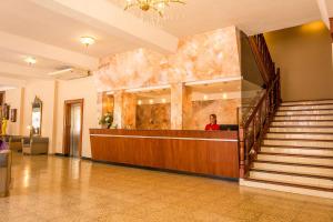 Un hombre sentado en un mostrador en un vestíbulo. en City Hotel Termal, en Termas de Río Hondo 49 fotos más