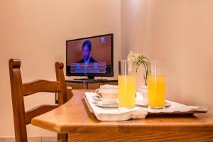 una mesa con dos vasos de zumo de naranja y un televisor en Tenuta Sciacca, en Falciano del Massico