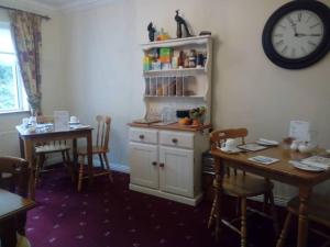 a dining room with a table and a clock on the wall at Corrib View Guesthouse h91rr72 in Galway