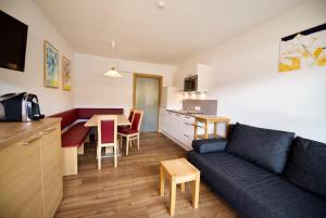 een woonkamer met een bank en een tafel en een keuken bij Haus Altenberger in Zell am See