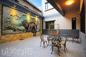 Happy Inn في يوشيه: فناء به طاولات وكراسي ولوحة خيول