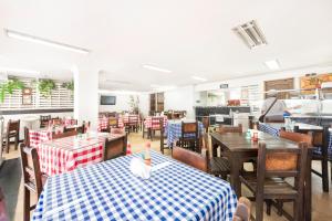 un restaurant avec des tables et des chaises et une cafétéria dans l'établissement Ayenda 1120 Hotel Comercial, à Pereira