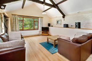 a living room with a couch and a table at Sunflowers Barn in Looe