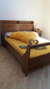 - un lit avec un cadre en bois et un cœur dans l'établissement Max 's Siusi Apartement, à Alpe di Siusi