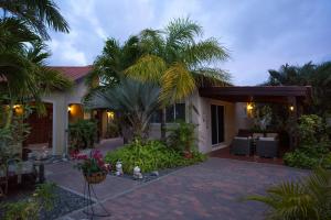 een huis met palmbomen en een patio bij Costa Esmeralda Village in Palm-Eagle Beach