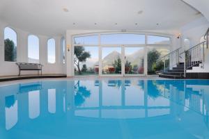 a swimming pool with a view of the mountains at Family Hotel Gutenberg in Schenna