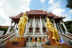two gold statues in front of a building at Smile Inn in Bangkok