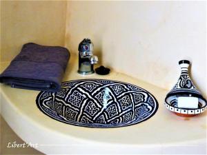 - un comptoir de salle de bains avec un lavabo et une serviette dans l'établissement Libert'Art, à Essaouira