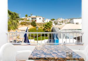 a balcony with a table and a view of the ocean at AT Almoraide Rooms Suites in Nerja