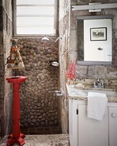 a bathroom with a stone wall and a sink at Golden Rock Nevis in Nevis