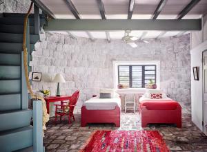 a room with two beds and a table and chairs at Golden Rock Nevis in Nevis