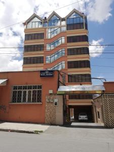 un edificio alto con un garaje frente a él en Hostal Río ibare en La Paz
