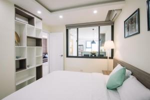 a bedroom with a large bed and a window at Da Nang Daisy Apartment in Danang