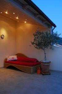 a bed in a room with a potted tree at Apartments & Rooms Luna in Bol