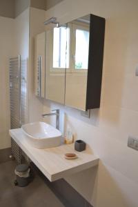 ein Badezimmer mit einem weißen Waschbecken und einem Spiegel in der Unterkunft La Bella Italia in Desenzano del Garda