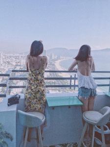 ダナンにあるDa Nang Daisy Apartmentの二人の女の子が街を見下ろすバルコニーに立っている